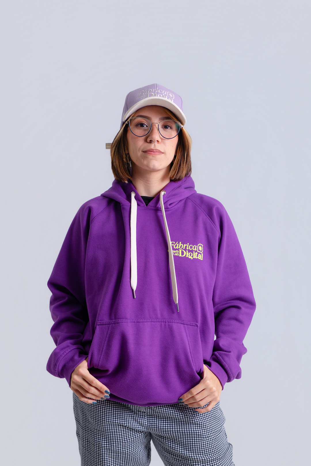 Integrante del equipo de Fábrica Digital con gorra y buzo morado